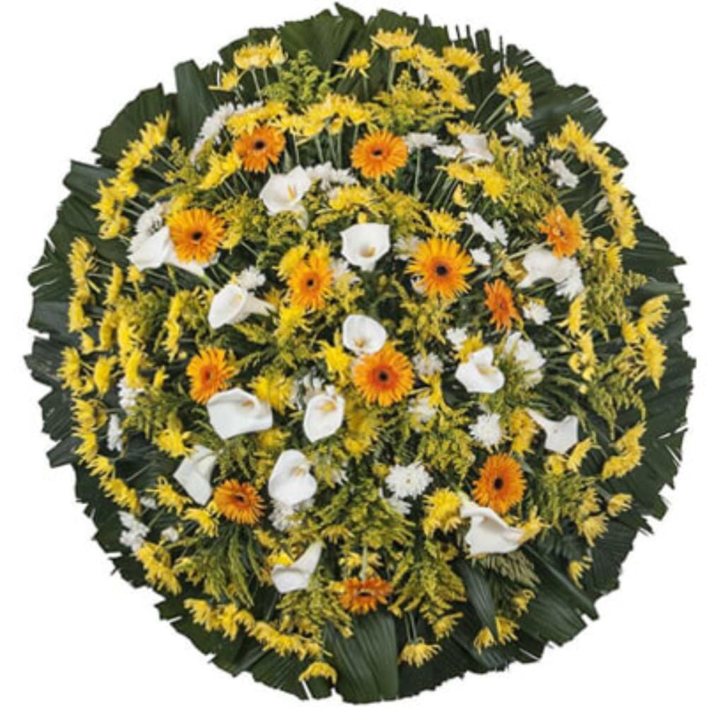 "Coroa de flores com gerberas amarelas, copo-de-leite e xenas brancas nos tamanhos P (R$295,00), M (R$345,00) e G (R$383,00)"